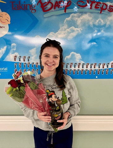 Heather Romig, RN pictures with flowers and DAISY award