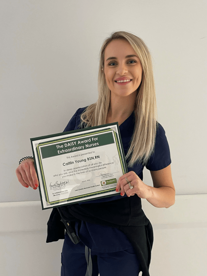 Photo of madison dyer holding dasiy award certificate