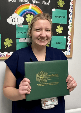 Photo of madison dyer holding dasiy award certificate